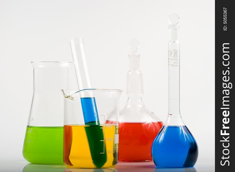 Various colorful flasks over white background