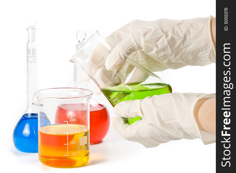 Various colorful flasks and hand in glove over white background