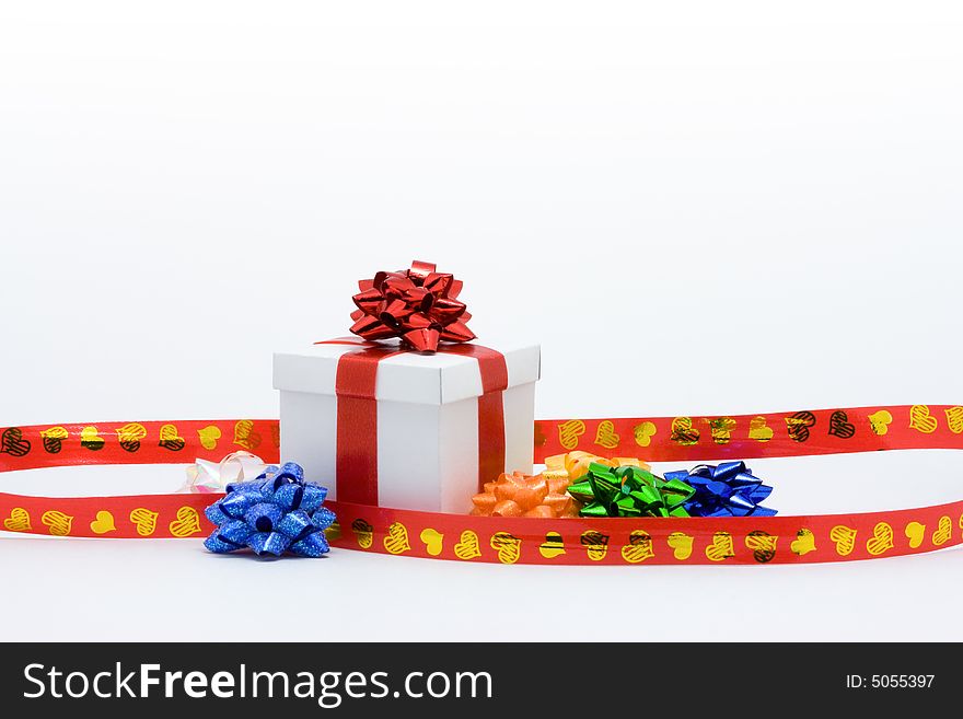 White fancy box with red ribbons over white background