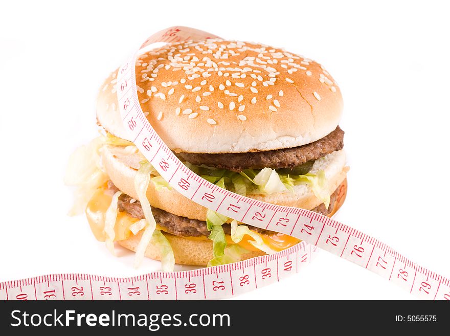 Bread with fried meat, cheese, onion, lettuce and measuring tape isolated on a  white background. Bread with fried meat, cheese, onion, lettuce and measuring tape isolated on a  white background.