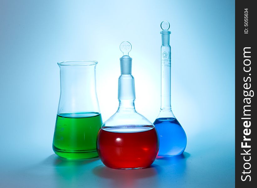 Various colorful flasks over blue tone background