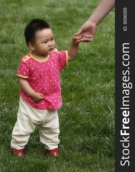 A chinese baby girl on the meadow