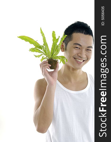 Young man on holding a small plant