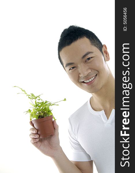 Young man on holding a small plant