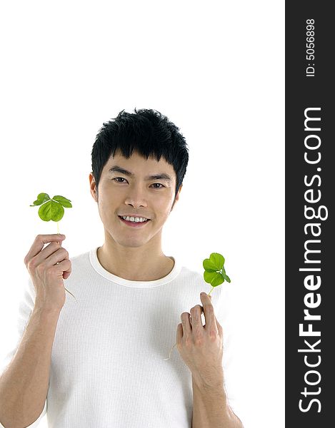 Young man holding up a green leaf by posing