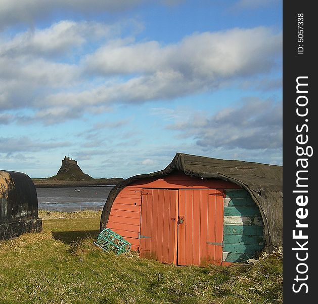 A boat shed on Lindisfarne Island, with Lindisfarne Castle in the backround.