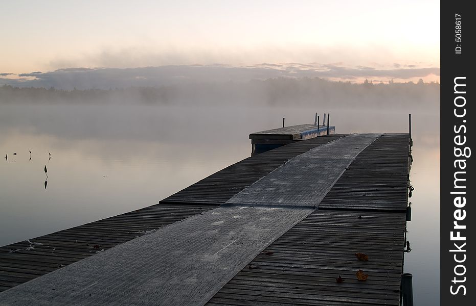 Quiet pier on a misty lake on an early autumn day. Quiet pier on a misty lake on an early autumn day.