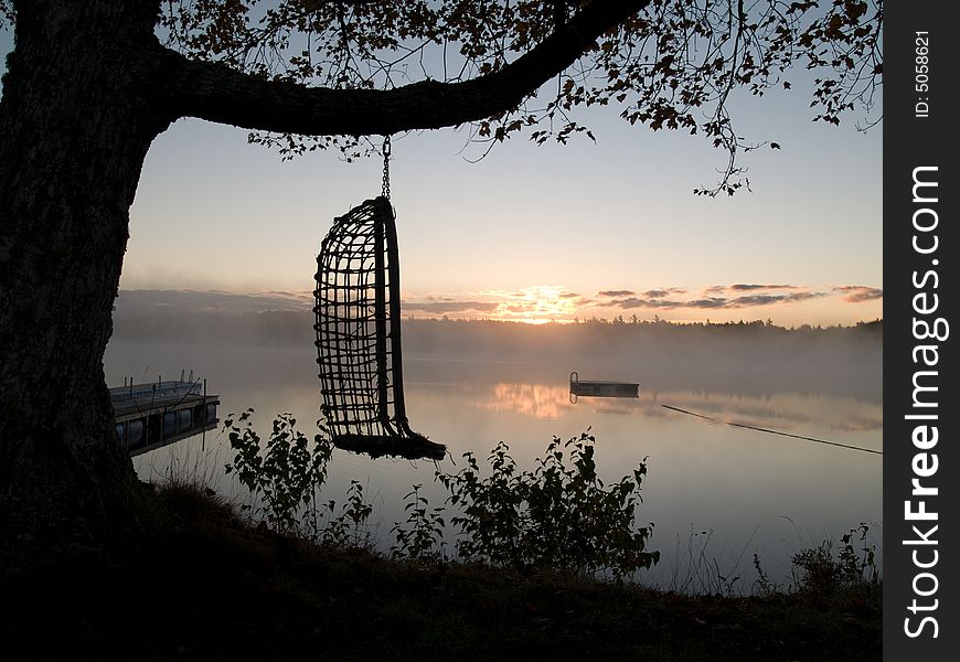 Hammok hanging in front on Lietash Lake on an cool foggy sunrise in autumn. Hammok hanging in front on Lietash Lake on an cool foggy sunrise in autumn.