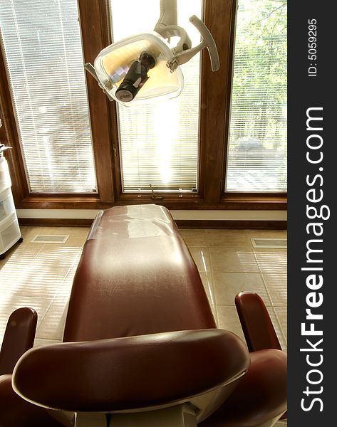 A red dental reclining chair at a dentists office. A red dental reclining chair at a dentists office