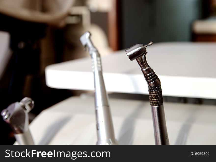 A dentists drill on a table in office room. A dentists drill on a table in office room.