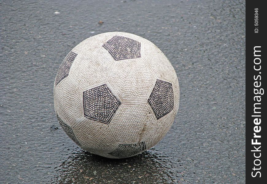 Old deflated football abandoned in the rain. Old deflated football abandoned in the rain