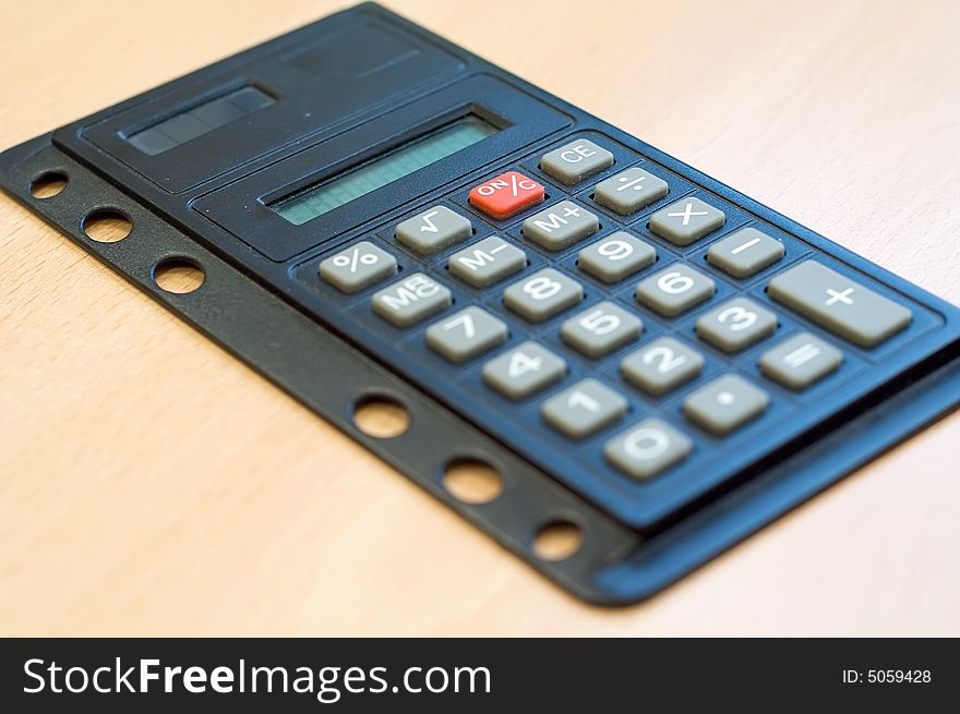 Pocket calculator on wooden desk