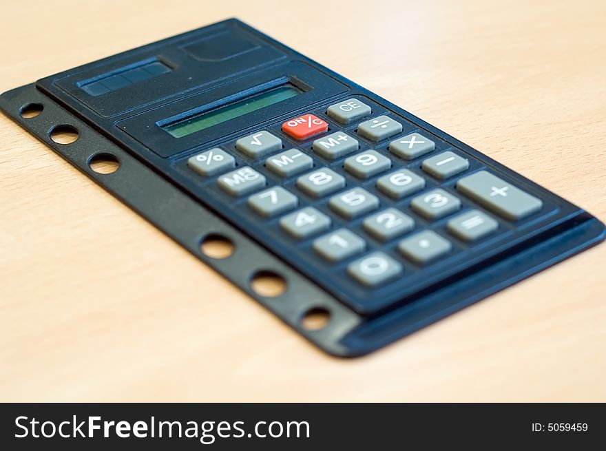 Pocket calculator on wooden desk
