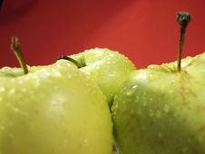 Green Apple On Red And Water Drops Royalty Free Stock Photos