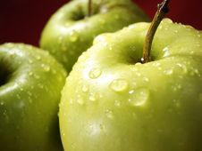 Green Apple On Red And Water Drops Stock Photography