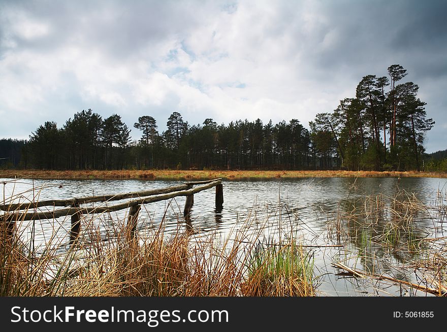 A lake in forest and dramatic sky