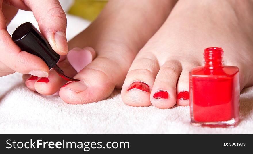 Red nail polish on her foot fingers. Red nail polish on her foot fingers