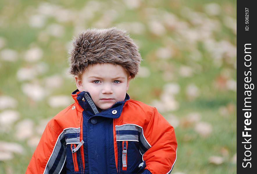 A small child in cold weather with a coon skin cap on. A small child in cold weather with a coon skin cap on