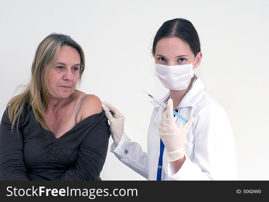 A shot of a female nurse about to give female patient a shot. A shot of a female nurse about to give female patient a shot.