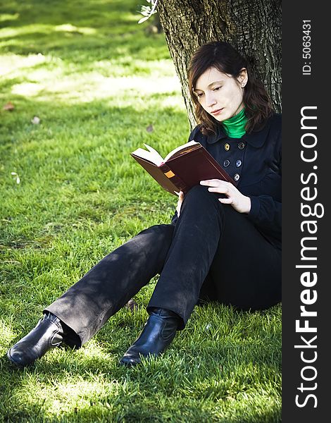 Young woman enjoying a book in the park. Young woman enjoying a book in the park