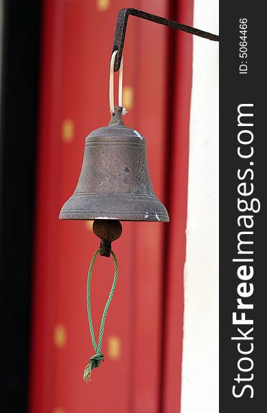 Hanging metal bell at the entrance to a building.