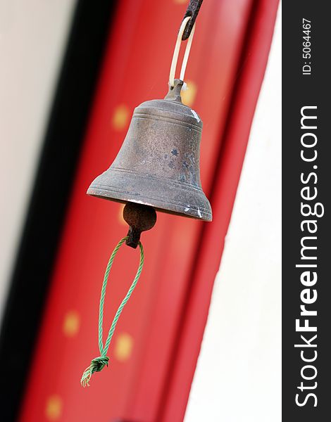 Hanging metal bell at the entrance to a building.