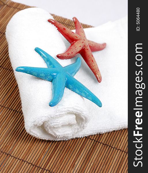 Colorful starfish on a white towel - spa and beauty. Colorful starfish on a white towel - spa and beauty.