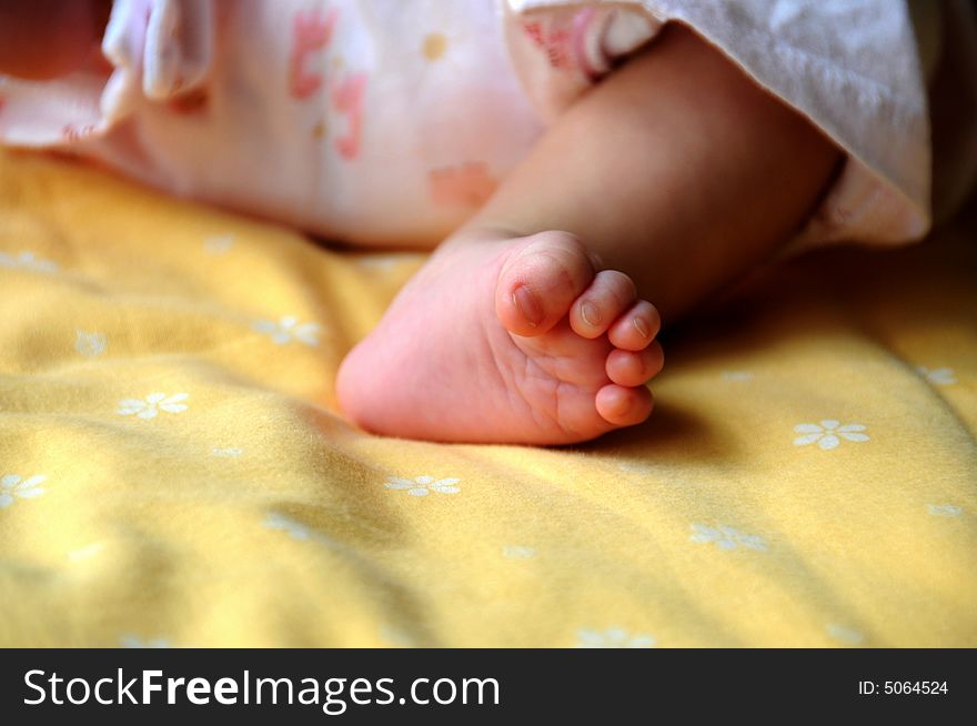 The bare foot with grasped fingers of a newborn baby. It's fleshly with the pink color. So lovely and cute. The bare foot with grasped fingers of a newborn baby. It's fleshly with the pink color. So lovely and cute.