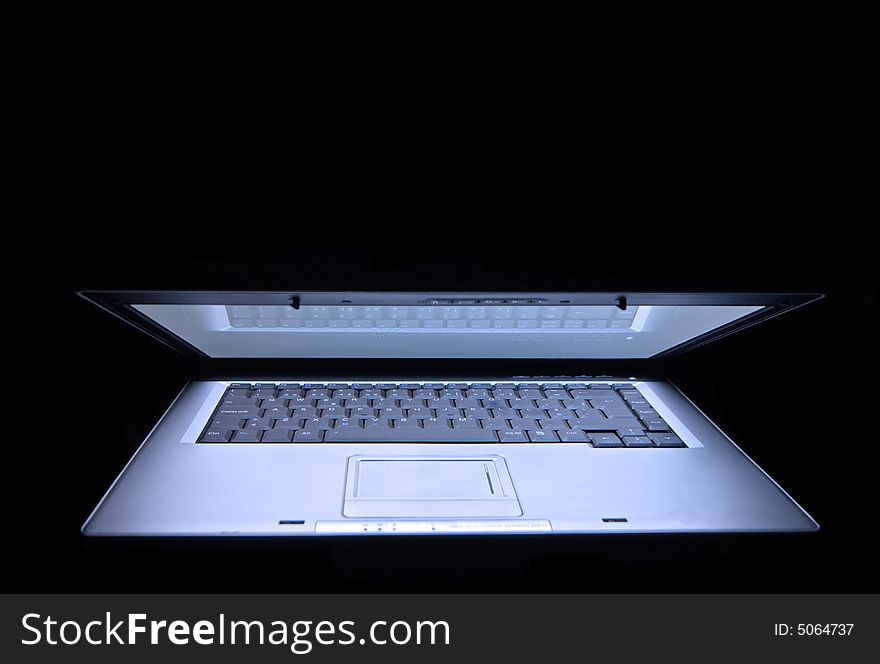 Laptop in a black background using only avaible light. Laptop in a black background using only avaible light