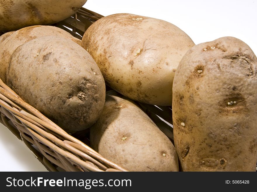Unpeeled raw potatoes in a basket.
