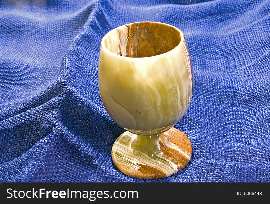 A small marbleized goblet from the middle east on blue burlap. A small marbleized goblet from the middle east on blue burlap.