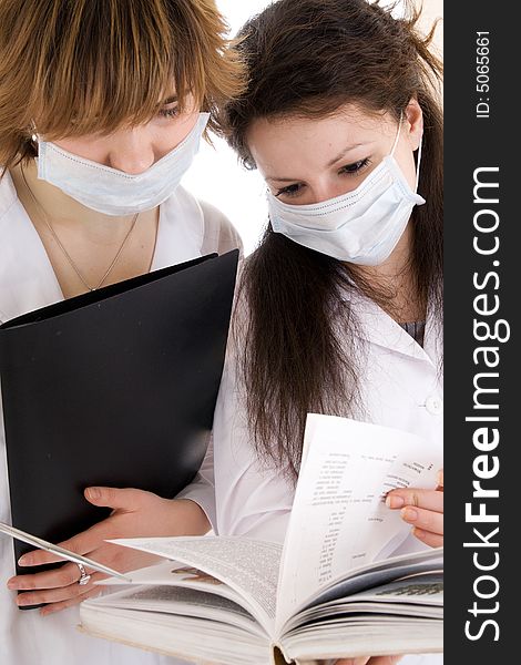 The two young attractive nurse with a documents isolated on a white background. The two young attractive nurse with a documents isolated on a white background