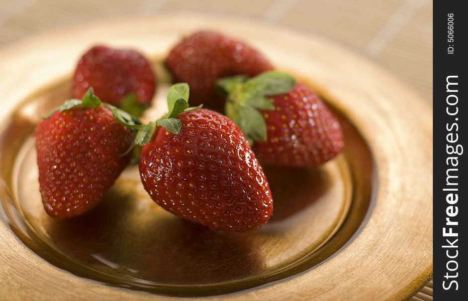 Strawberry fruit on golden plte close up shoot