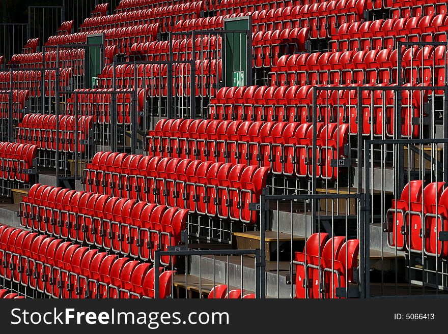 Rows of empty red seats in sports stadium