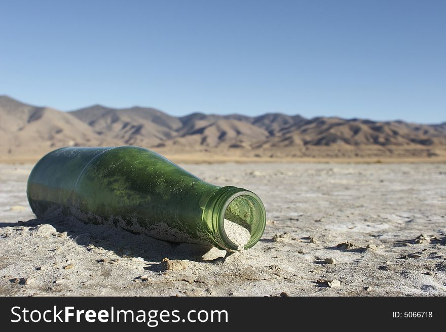 Bottle partially buried in the playa of the Carson Sink.  Nevada, USA. Bottle partially buried in the playa of the Carson Sink.  Nevada, USA