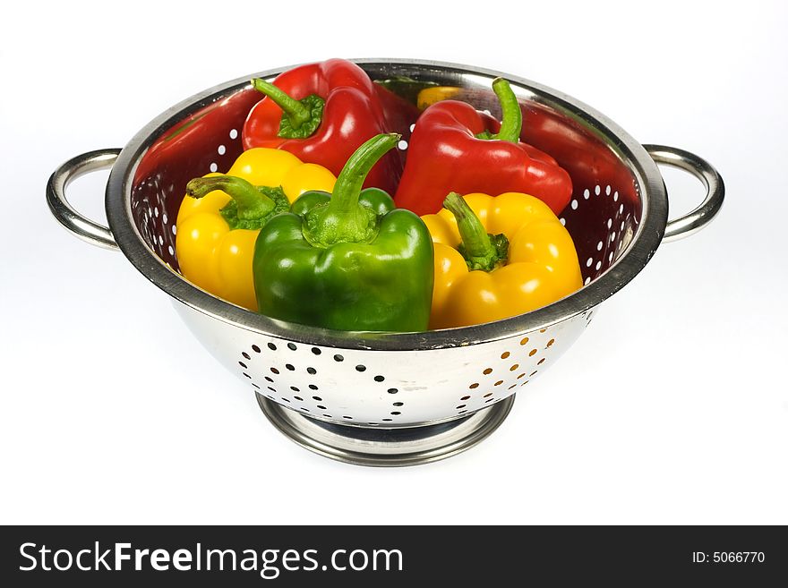 Paprikas in Colander on white background