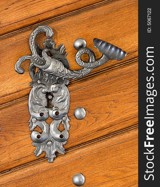 An antique beaten door handle. An antique beaten door handle