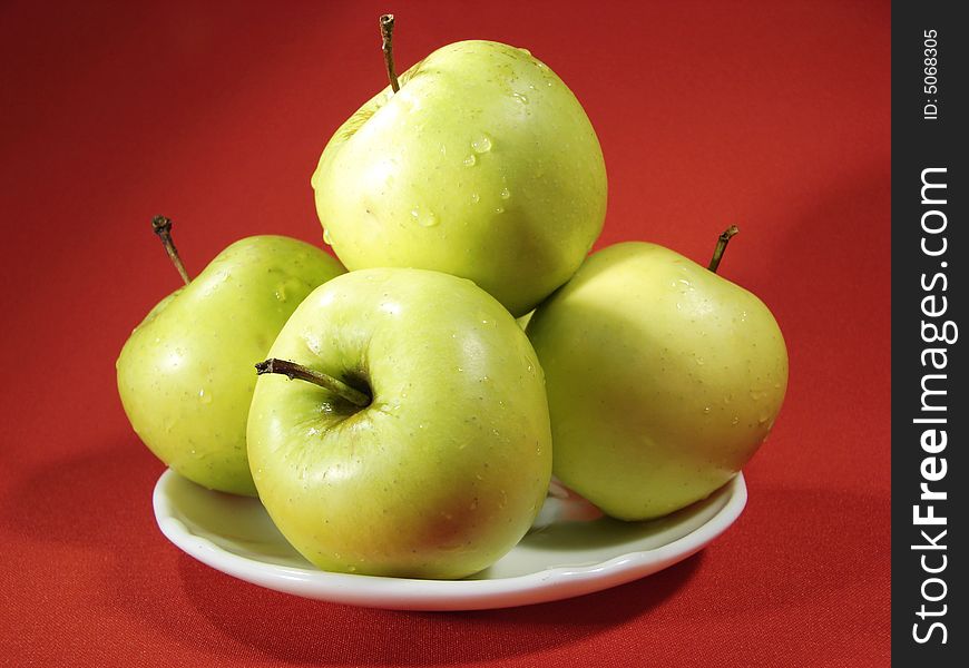 Several green apples on red