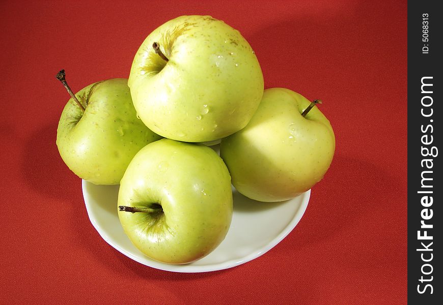 Several green apples on red