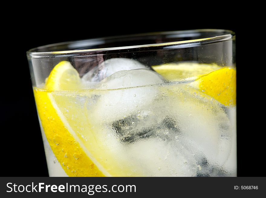 A glass of soda water with a slice of lemon. A glass of soda water with a slice of lemon