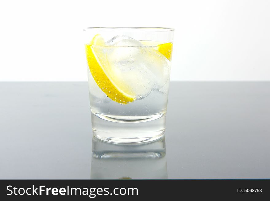 A glass of soda water with a slice of lemon. A glass of soda water with a slice of lemon