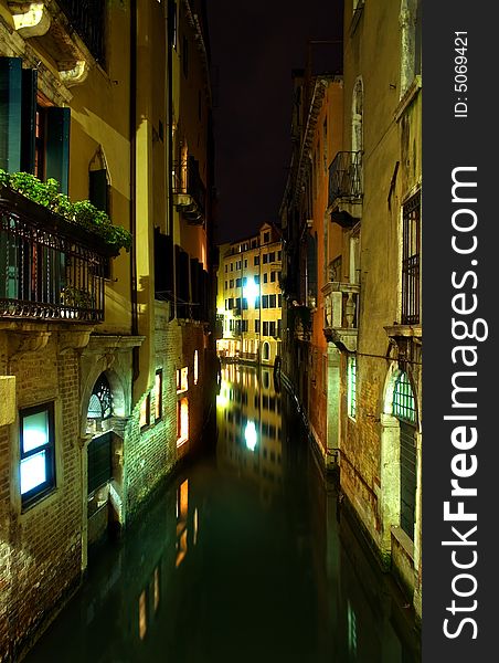 Night time view along a canal in Venice, Italy.