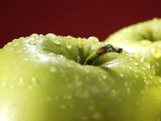 Green Apple On Red With Water Drops Stock Photo