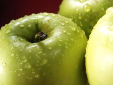 Green Apple On Red With Water Drops Royalty Free Stock Photography