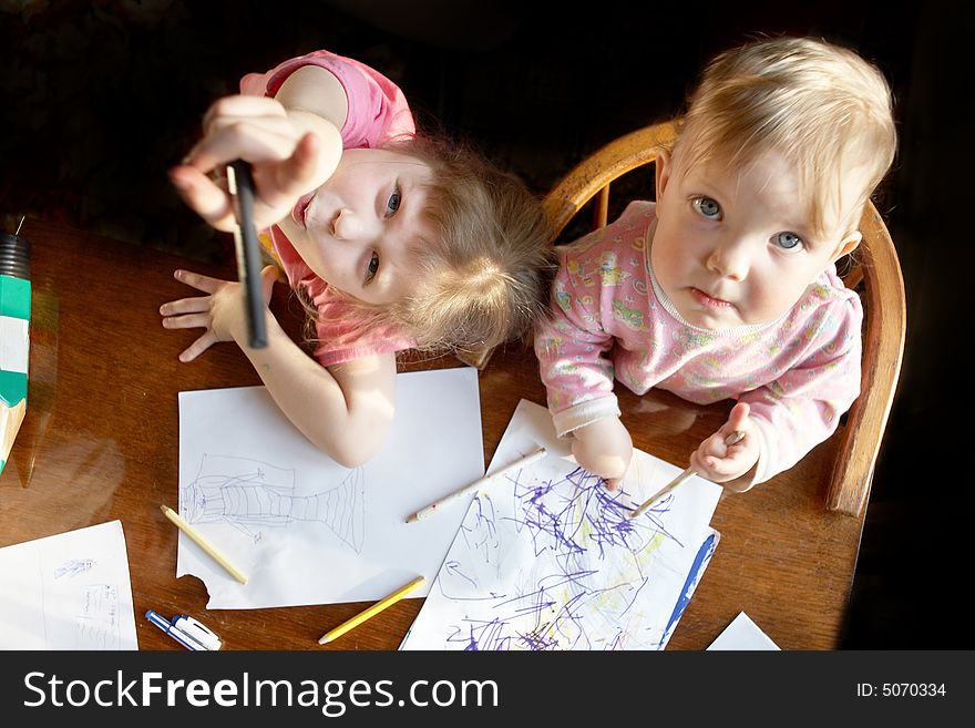 A two girls with pencils drawing a picture. A two girls with pencils drawing a picture