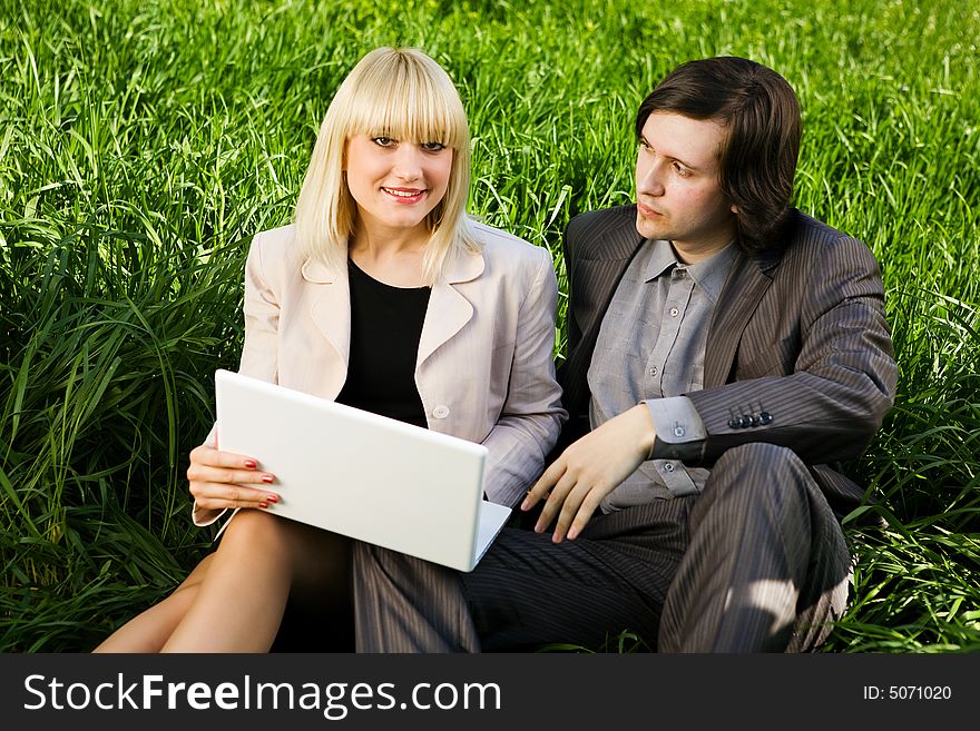 Boy and girl dressed for business with laptop on the grass. Boy and girl dressed for business with laptop on the grass