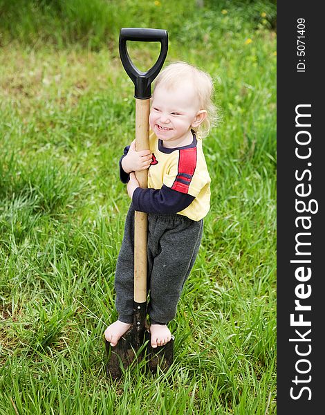 Small girl on the shovel in the garden. Small girl on the shovel in the garden