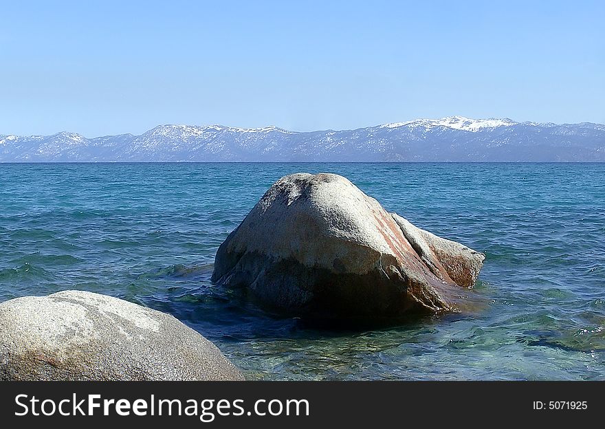 Two rocks sit in the beautiful water. Two rocks sit in the beautiful water