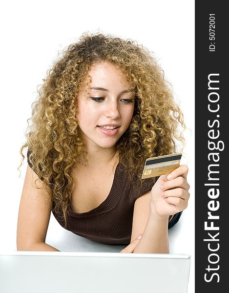 A beautiful young women using a credit card and a computer to shop online. A beautiful young women using a credit card and a computer to shop online