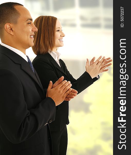 Two business people clapping hand while looking to the side as if they are listening to presentaion. Two business people clapping hand while looking to the side as if they are listening to presentaion